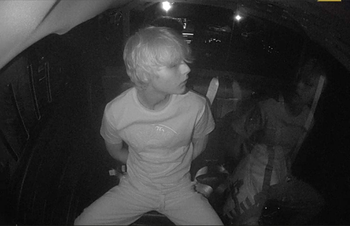 Will Purvis in the back of a car late at night, caught in grainy black-and-white infrared, turned toward the window